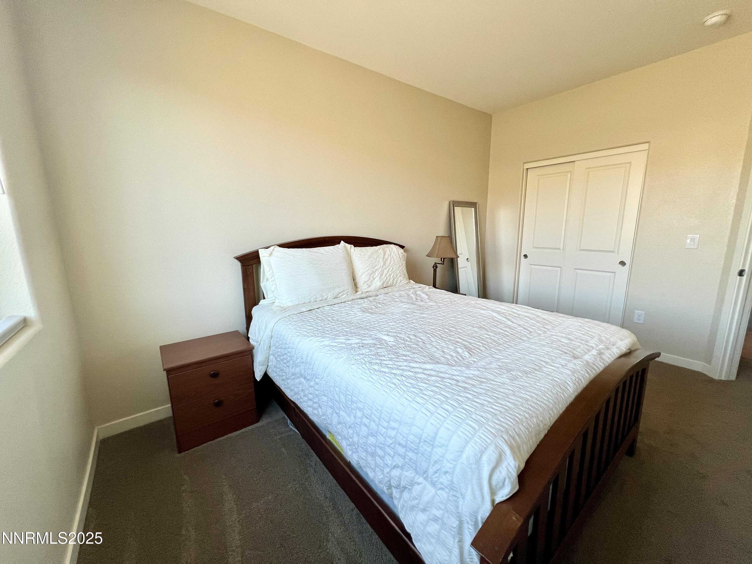 4969 Cavestone Road Sun Valley, NV 89433 - Photo 23 of 40 a bedroom with a bed and a lamp with wall
