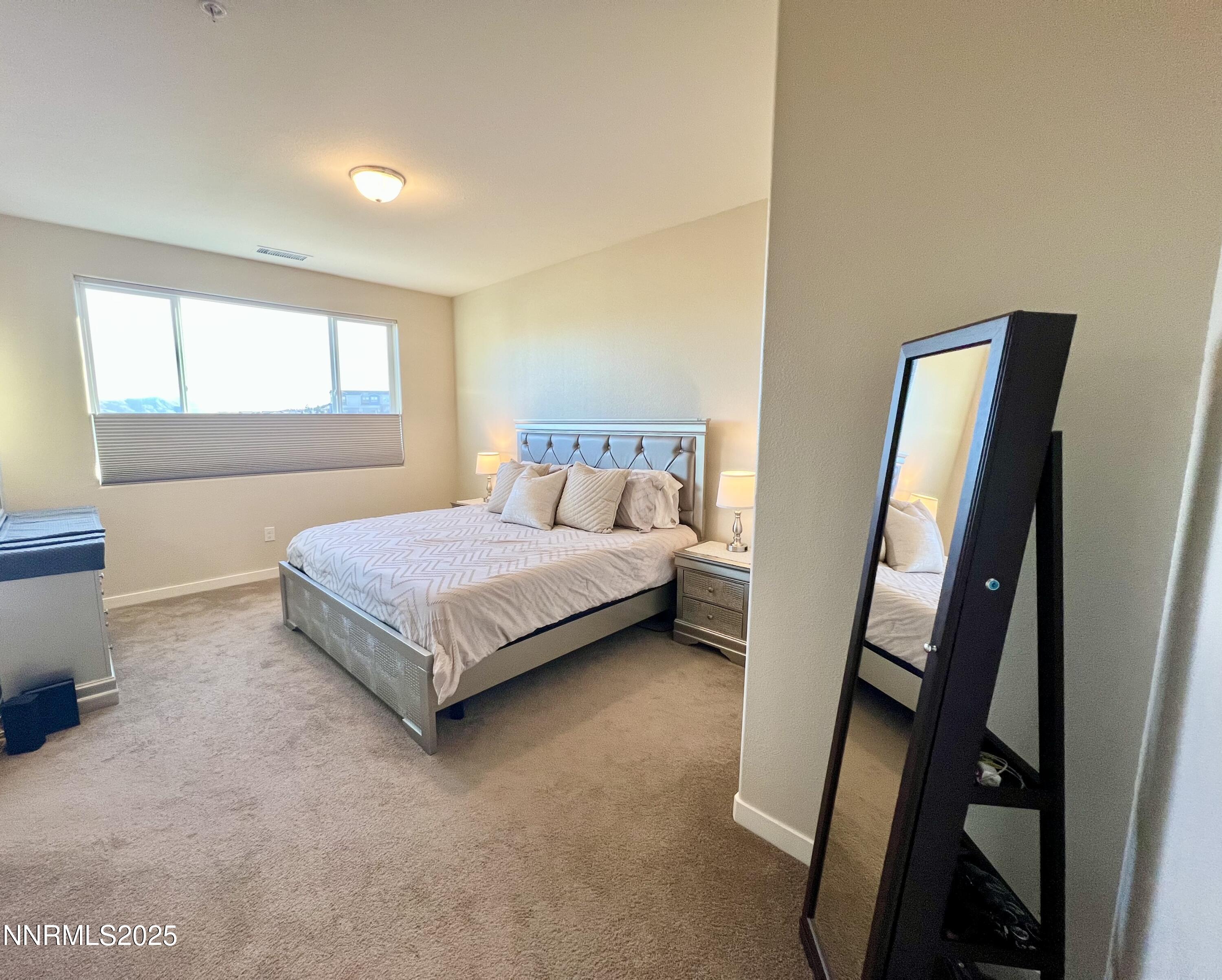 4969 Cavestone Road Sun Valley, NV 89433 - Photo 30 of 40 a bedroom with a bed and a mirror