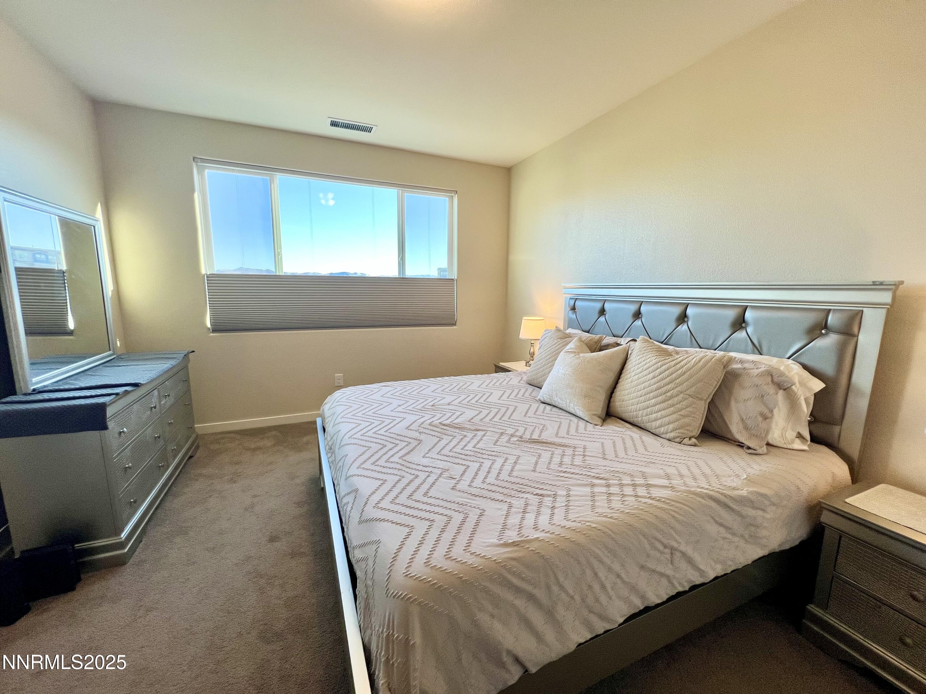 4969 Cavestone Road Sun Valley, NV 89433 - Photo 31 of 40 a bed sitting in a bedroom next to a window