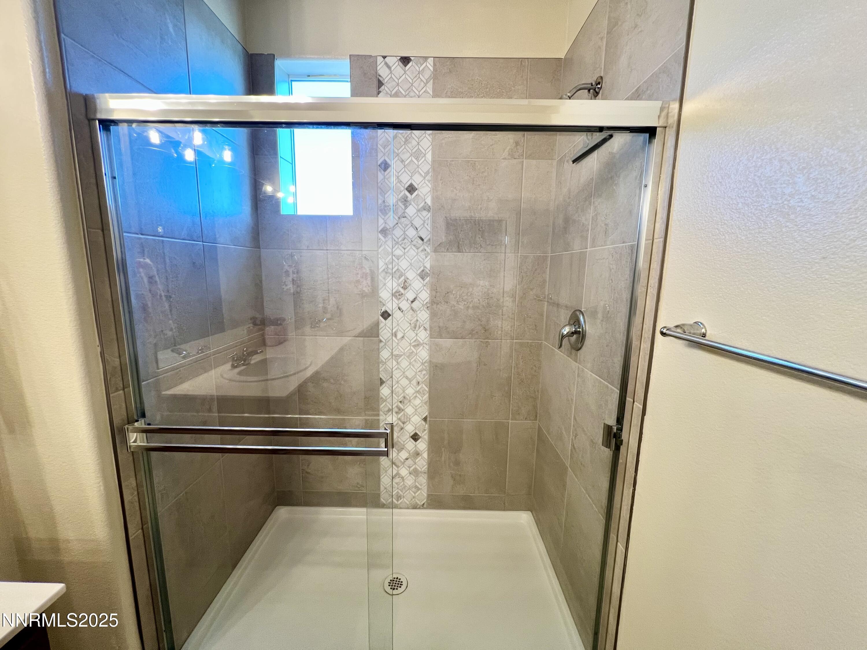 4969 Cavestone Road Sun Valley, NV 89433 - Photo 34 of 40 a bathroom with a shower and a mirror