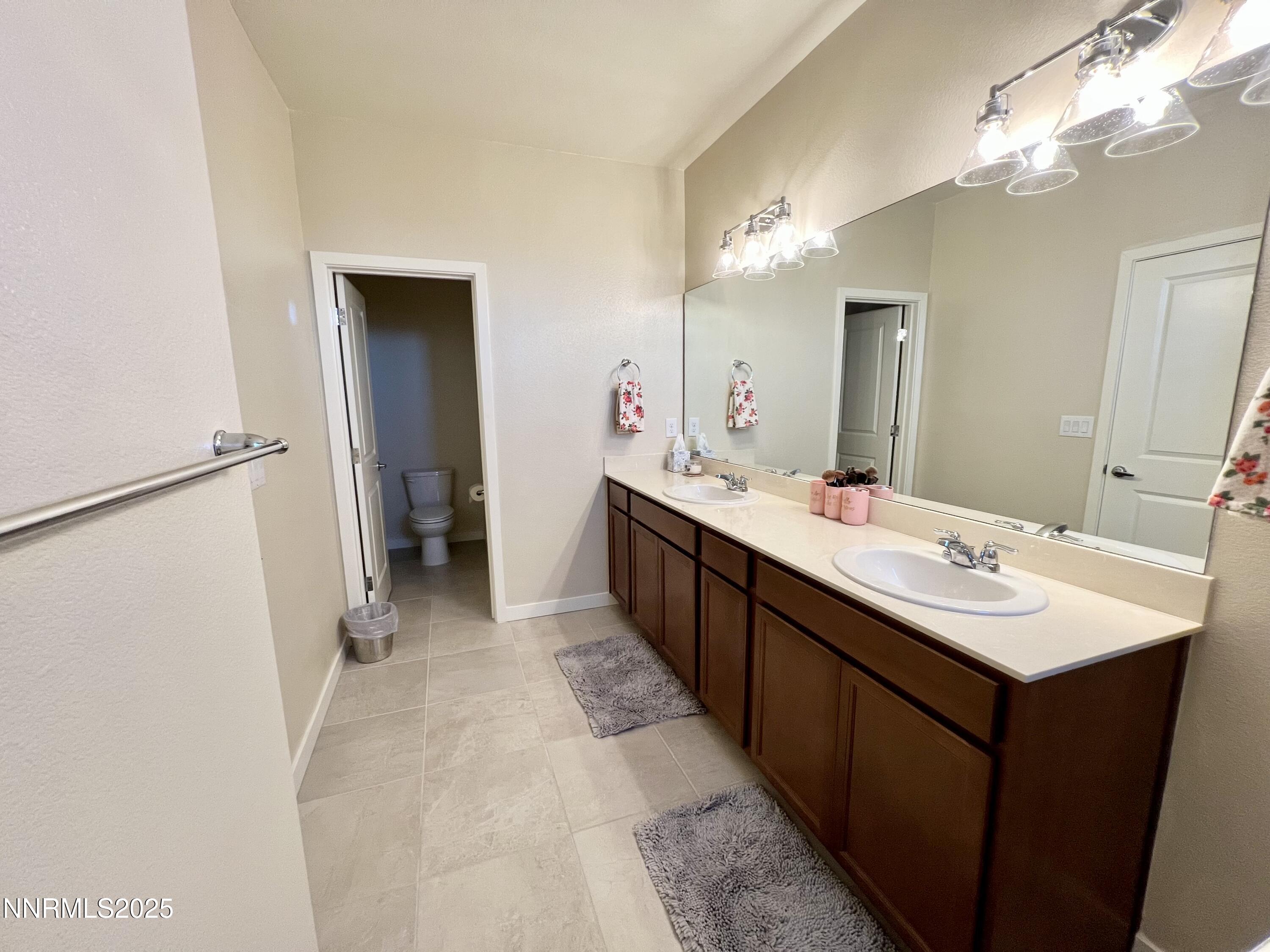 4969 Cavestone Road Sun Valley, NV 89433 - Photo 36 of 40 a bathroom with a double vanity sink and a mirror