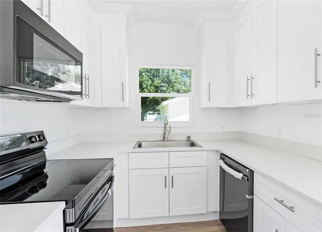 a kitchen with appliances cabinets and a window