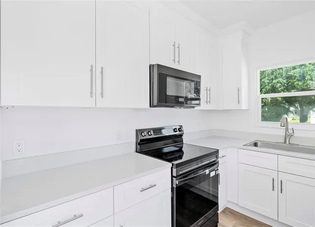 a kitchen with a sink stove and microwave