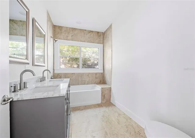 a bathroom with a bathtub sink and mirror