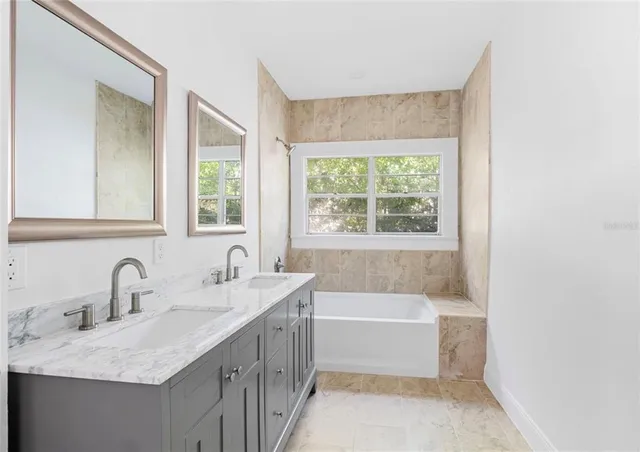 a bathroom with a tub sink and mirror