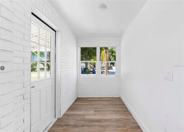 a view of hallway with wooden floor and front door