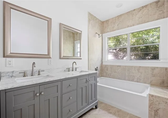 a bathroom with a tub a sink and a window