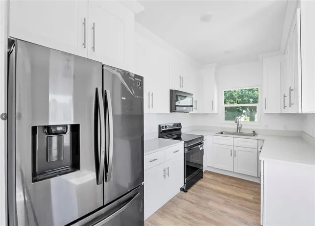 a kitchen with stainless steel appliances a refrigerator sink and cabinets