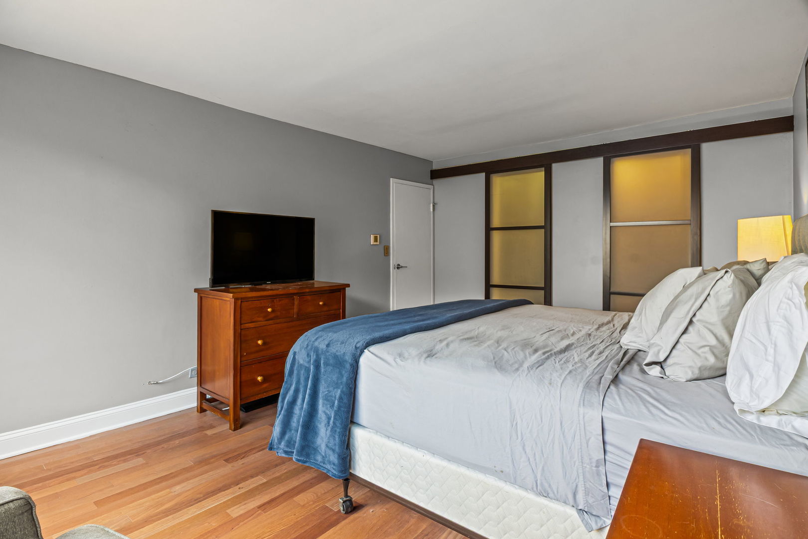 3150 North Sheridan Road, Unit 2C Chicago, IL 60657 - Photo 16 of 25 a bedroom with a bed and a flat tv screen on dresser