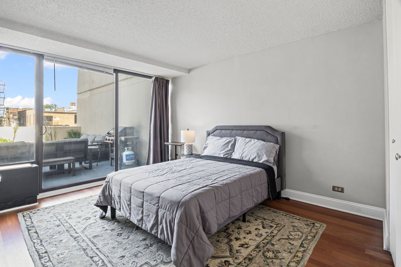 3150 North Sheridan Road, Unit 2C Chicago, IL 60657 - Photo 18 of 25 a bedroom with a bed lamp and a rug