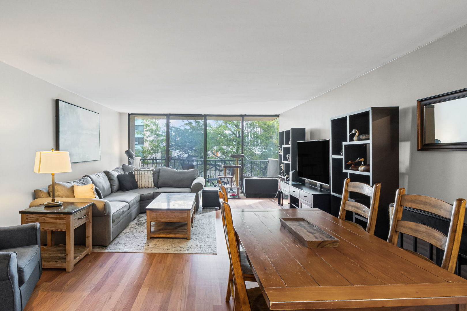 3150 North Sheridan Road, Unit 2C Chicago, IL 60657 - Photo 2 of 25 a living room with furniture a flat screen tv and a floor to ceiling window