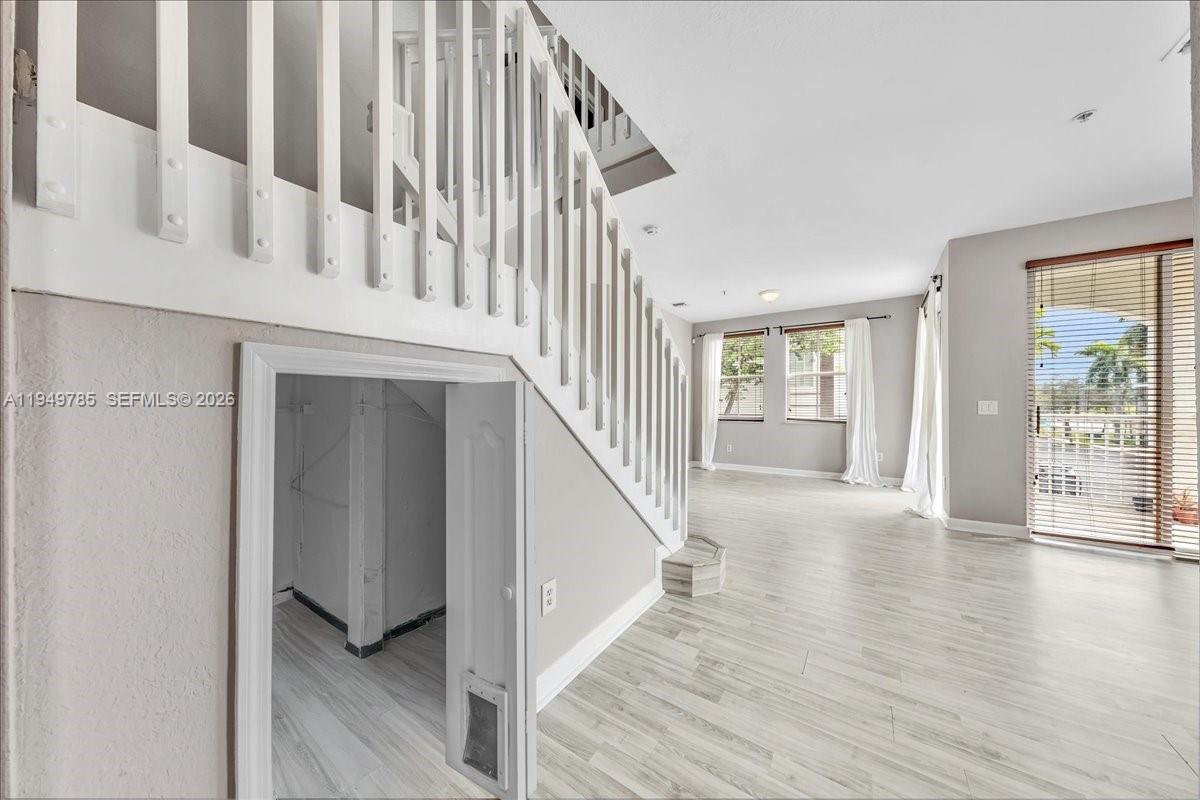 4341 Southwest 160th Avenue, Unit 201 Miramar, FL 33027 - Photo 12 of 53 a view of an entryway with wooden floor leading to a furnished livingroom and windows