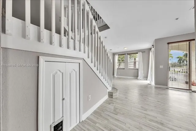 a view of staircase with wooden floor and white walls