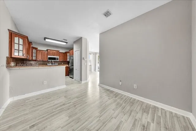 a view of a kitchen with wooden floor and a kitchen