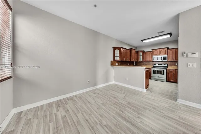 a view of a kitchen with wooden floor and electronic appliances