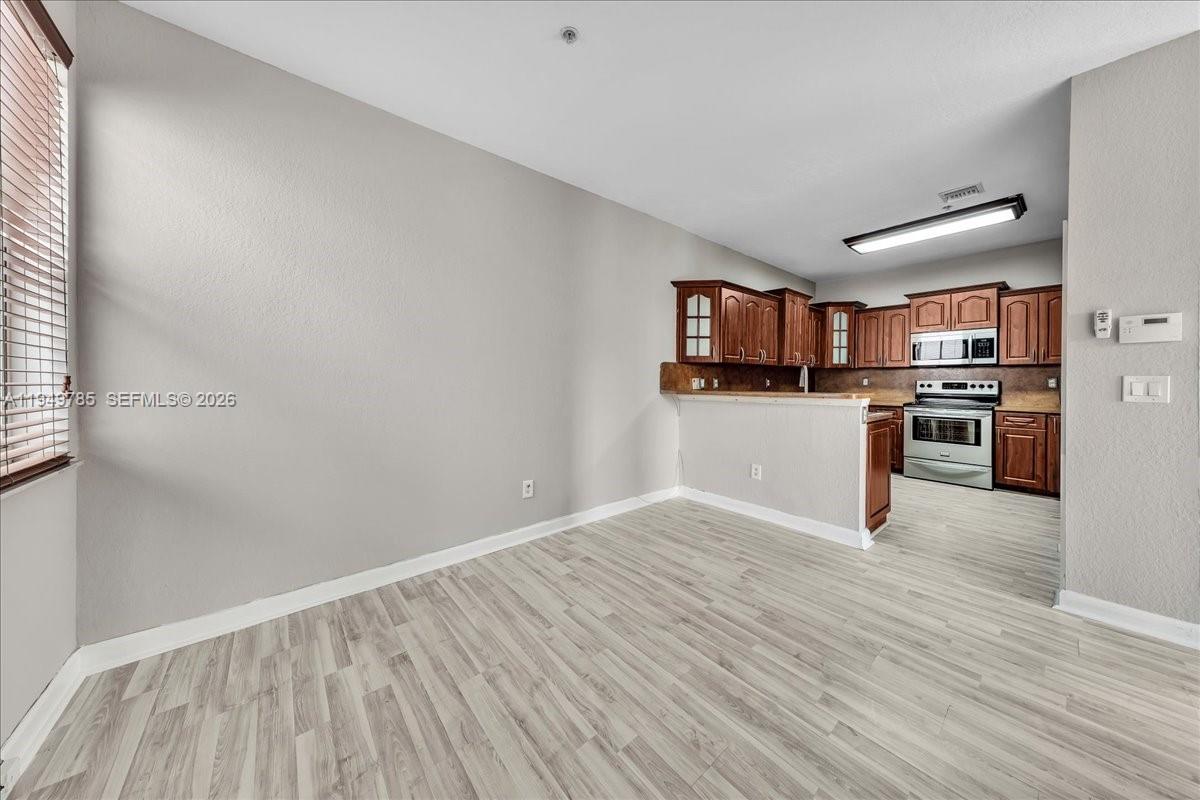 4341 Southwest 160th Avenue, Unit 201 Miramar, FL 33027 - Photo 19 of 53 a view of a kitchen with wooden floor and electronic appliances
