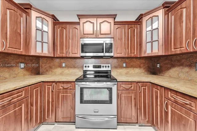a kitchen with granite countertop a sink stove and cabinets