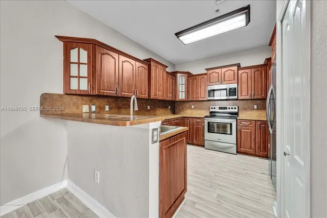 a kitchen with stainless steel appliances granite countertop a stove a sink and a refrigerator