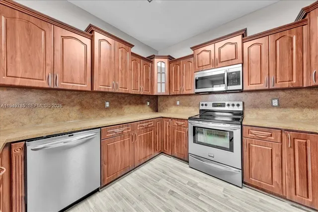 a kitchen with granite countertop wooden cabinets and stainless steel appliances