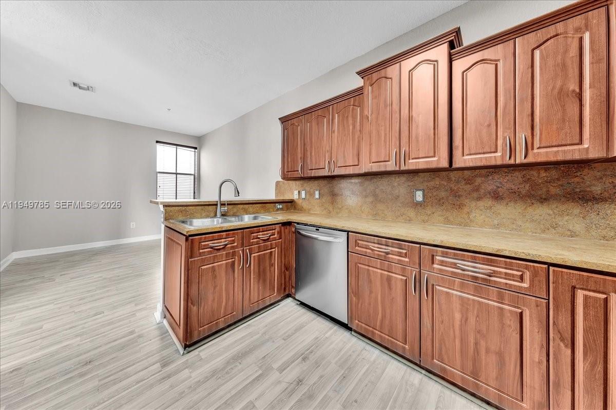 4341 Southwest 160th Avenue, Unit 201 Miramar, FL 33027 - Photo 23 of 53 a kitchen with stainless steel appliances granite countertop a sink a stove cabinets and wooden floor