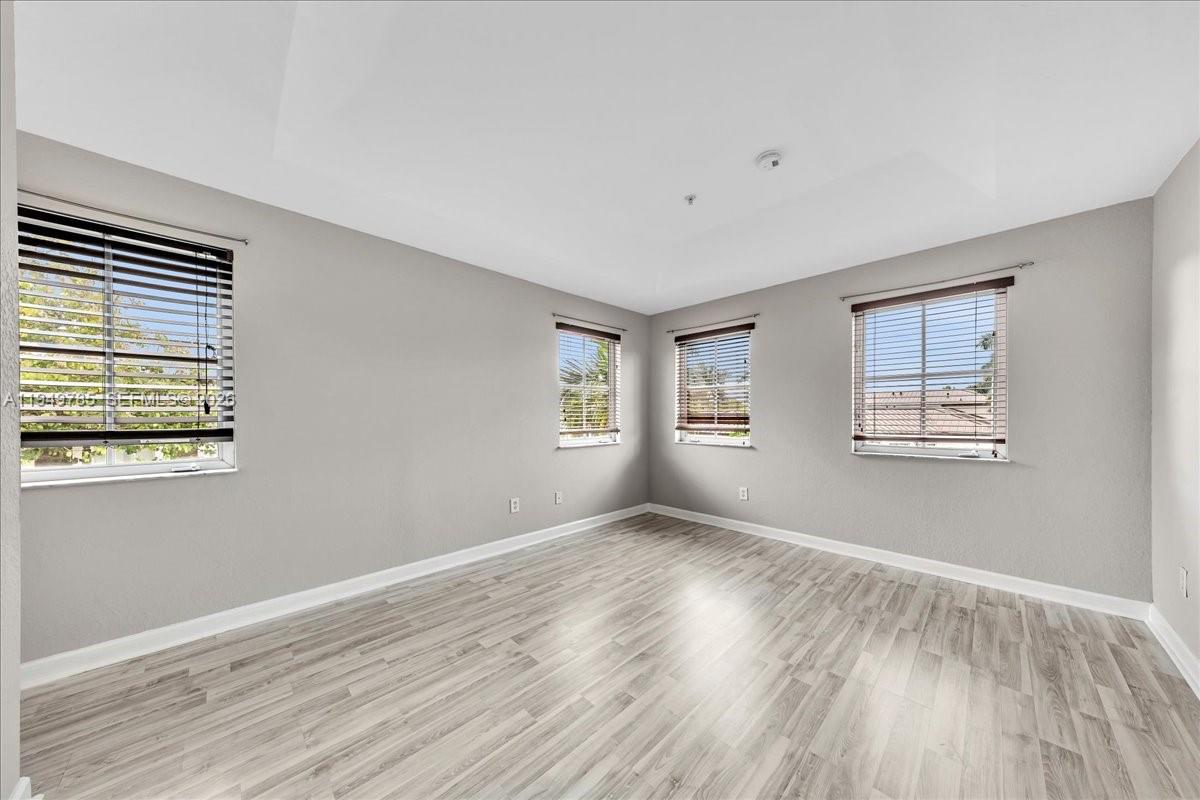 4341 Southwest 160th Avenue, Unit 201 Miramar, FL 33027 - Photo 35 of 53 a view of an empty room with wooden floor and a window