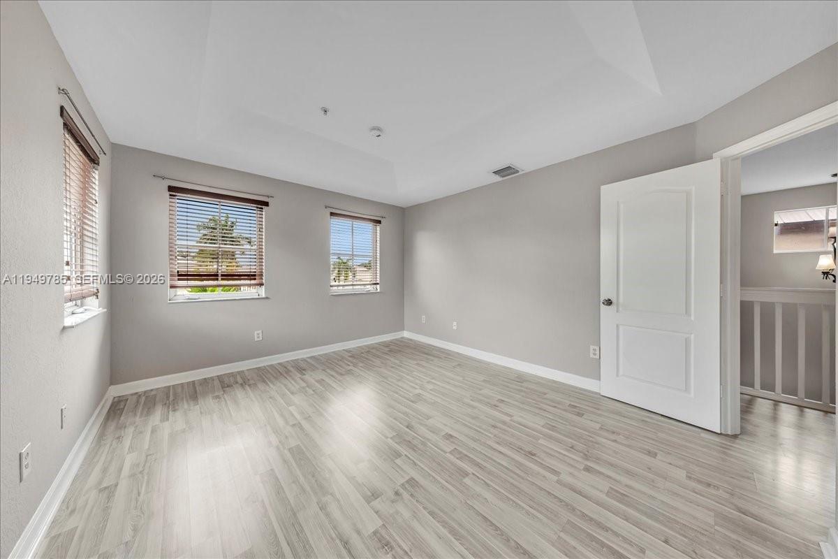 4341 Southwest 160th Avenue, Unit 201 Miramar, FL 33027 - Photo 38 of 53 a view of an empty room with wooden floor and a window