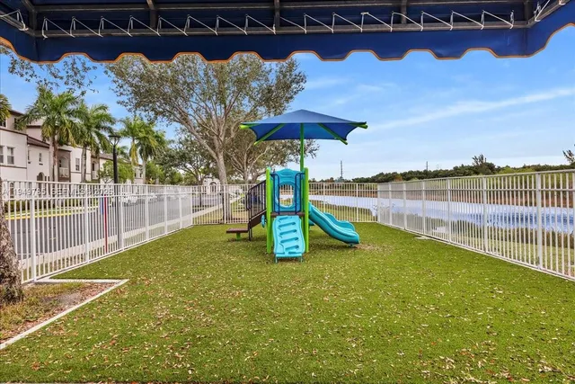 a view of a backyard with a swimming pool and sitting area