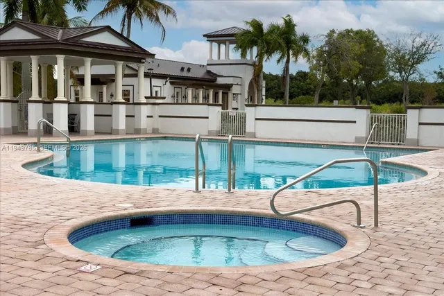a view of a house with pool and chairs