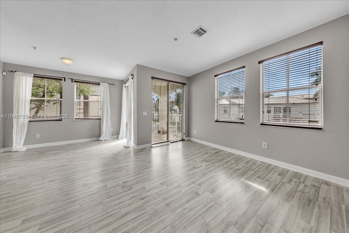 4341 Southwest 160th Avenue, Unit 201 Miramar, FL 33027 - Photo 10 of 53 a view of an empty room with a window and wooden floor