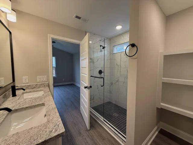 a bathroom with a granite countertop sink mirror and shower