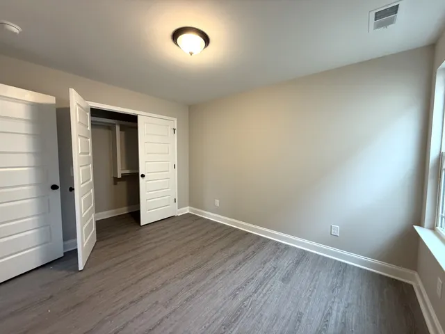 an empty room with wooden floor and closet