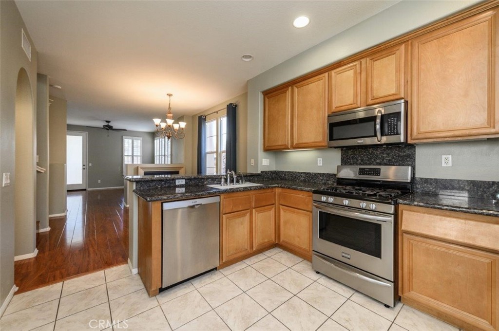 15 Tall Oak Irvine, CA 92603 - Photo 16 of 66 a kitchen with stainless steel appliances granite countertop a stove a sink and a microwave