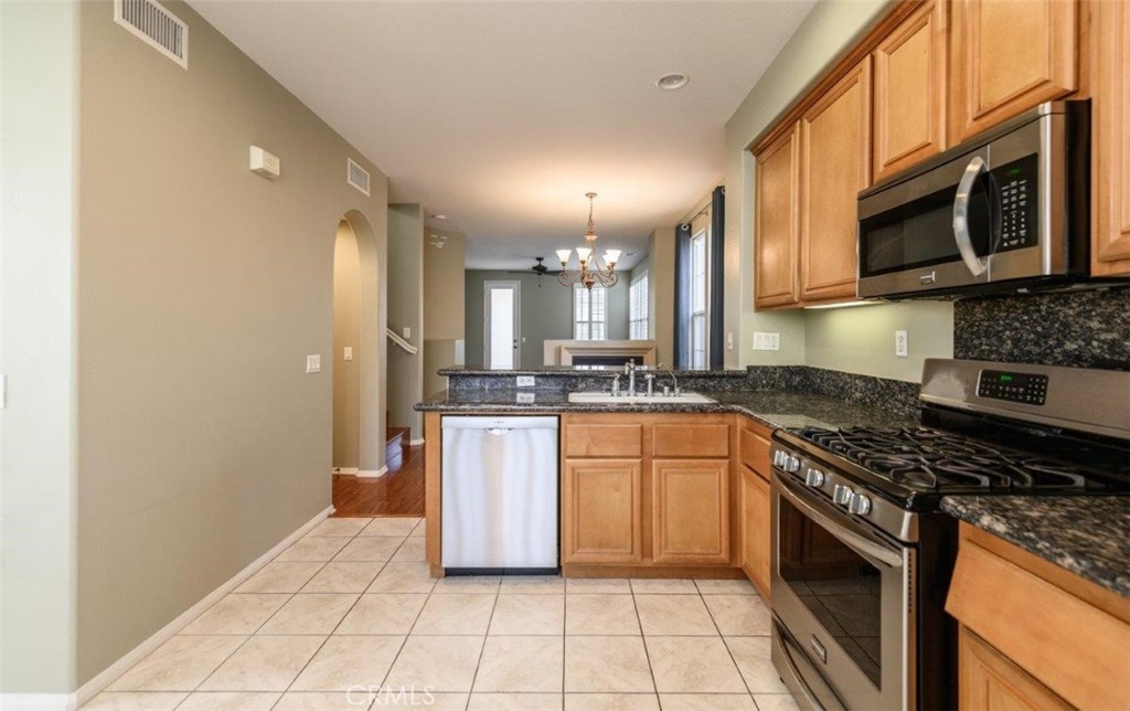 15 Tall Oak Irvine, CA 92603 - Photo 17 of 66 a kitchen with stainless steel appliances granite countertop a stove a sink and a microwave