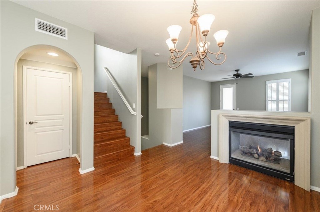 15 Tall Oak Irvine, CA 92603 - Photo 23 of 66 a view of a livingroom with wooden floor a fireplace a chandelier and entryway