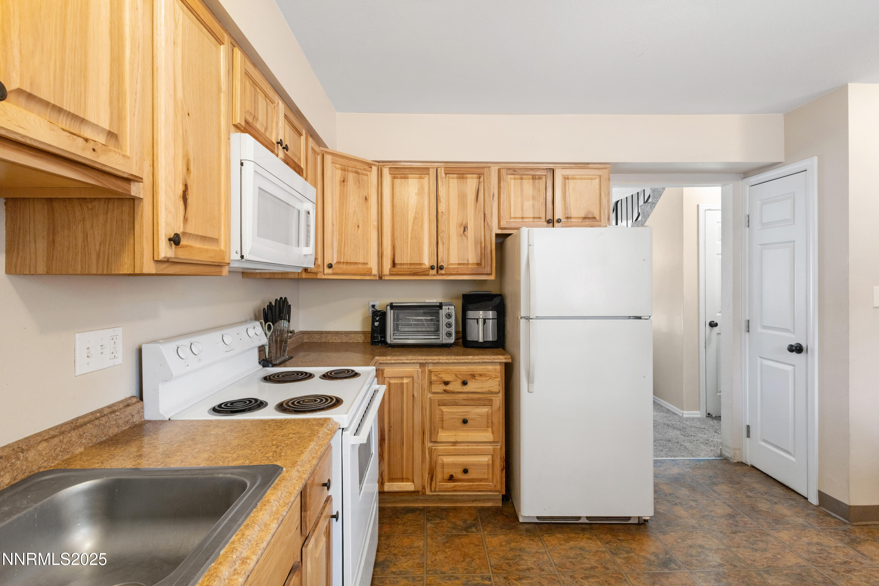 1414 East 9th Street, Unit 4 Reno, NV 89512 - Photo 6 of 16 a kitchen with a refrigerator sink stove and cabinets