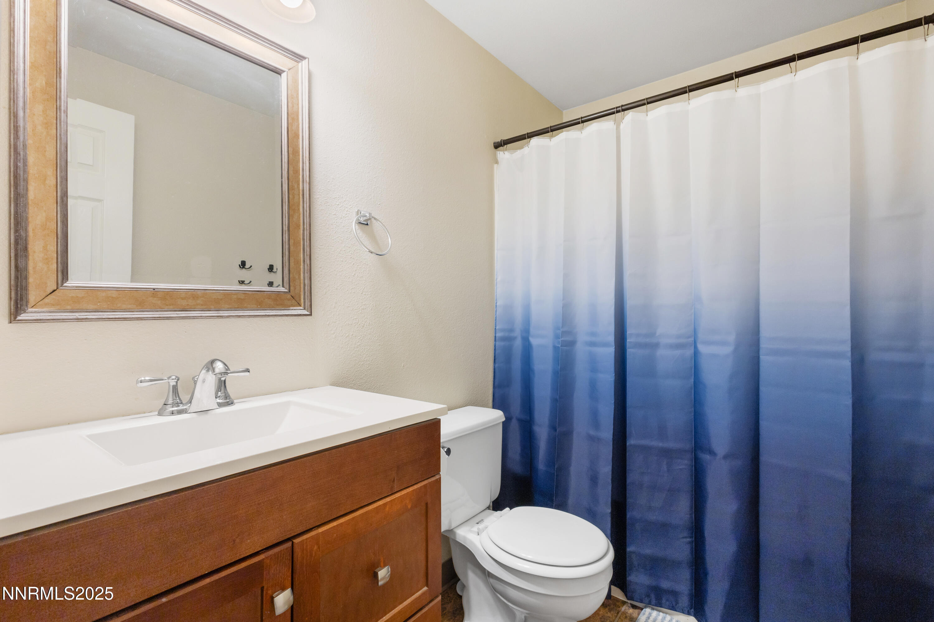 1414 East 9th Street, Unit 4 Reno, NV 89512 - Photo 10 of 16 a bathroom with a sink a toilet a mirror and shower curtain