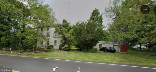 a couple of cars parked in front of a house and trees