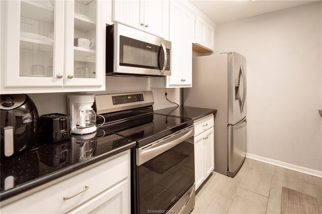 1501 Stallings Drive, Unit 60 College Station, TX 77840 - Photo 7 of 17 a kitchen with stainless steel appliances granite countertop a refrigerator and a stove top oven