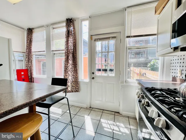 a kitchen with stainless steel appliances granite countertop a stove and a view of living room
