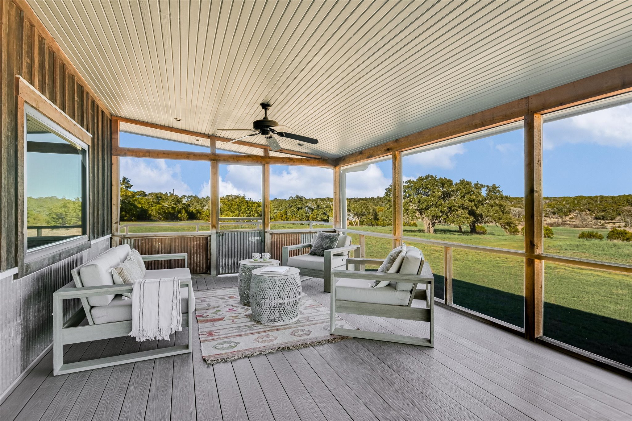 4698 Fischer Store Road Wimberley, TX 78676 - Photo 15 of 28 An inviting screened porch showcases clean wood-look flooring and views of the rolling green landscape.