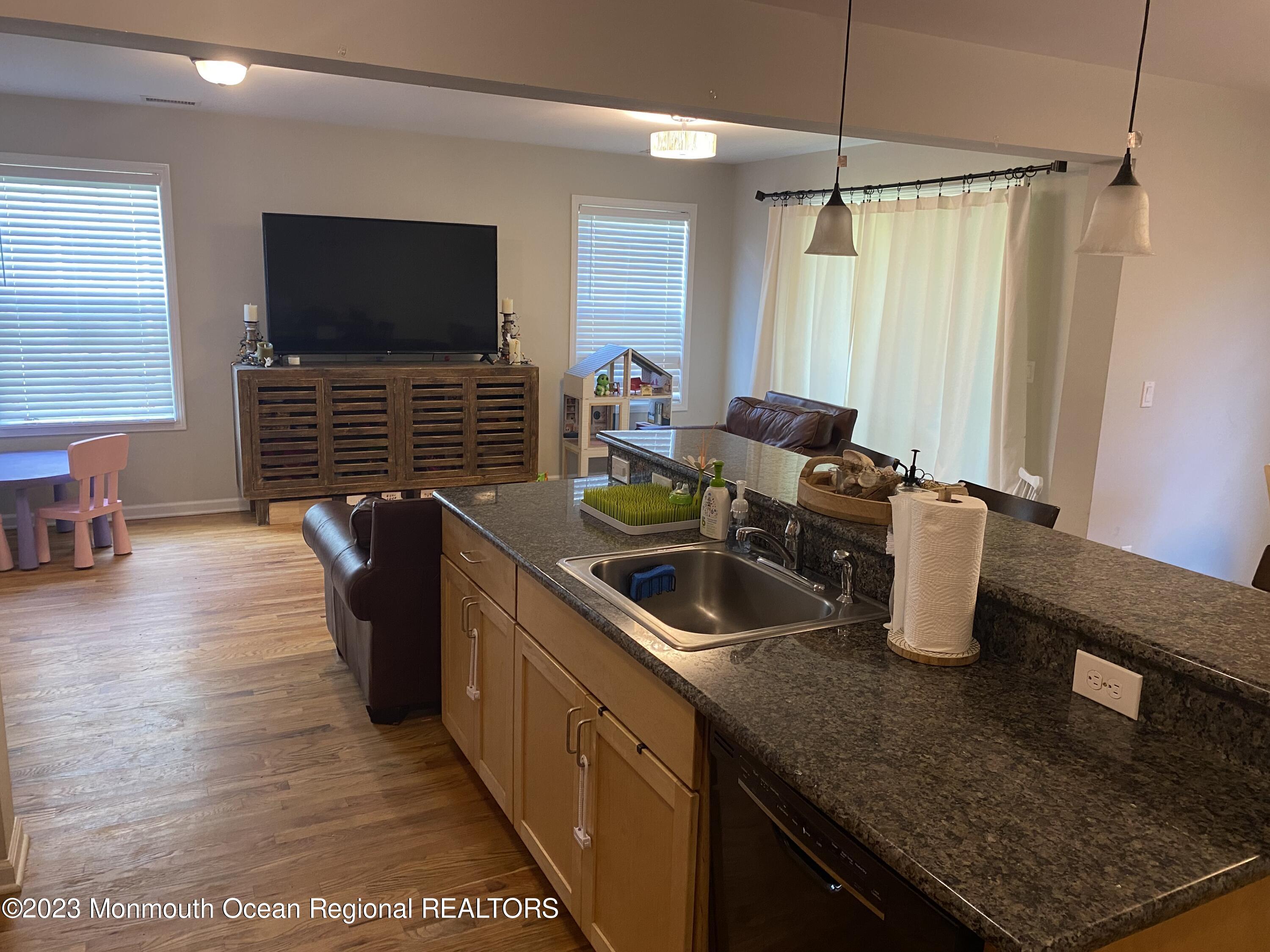 59 Court Street, Unit 2 Long Branch, NJ 07740 - Photo 2 of 8 a kitchen with granite countertop a sink a counter top space appliances and cabinets