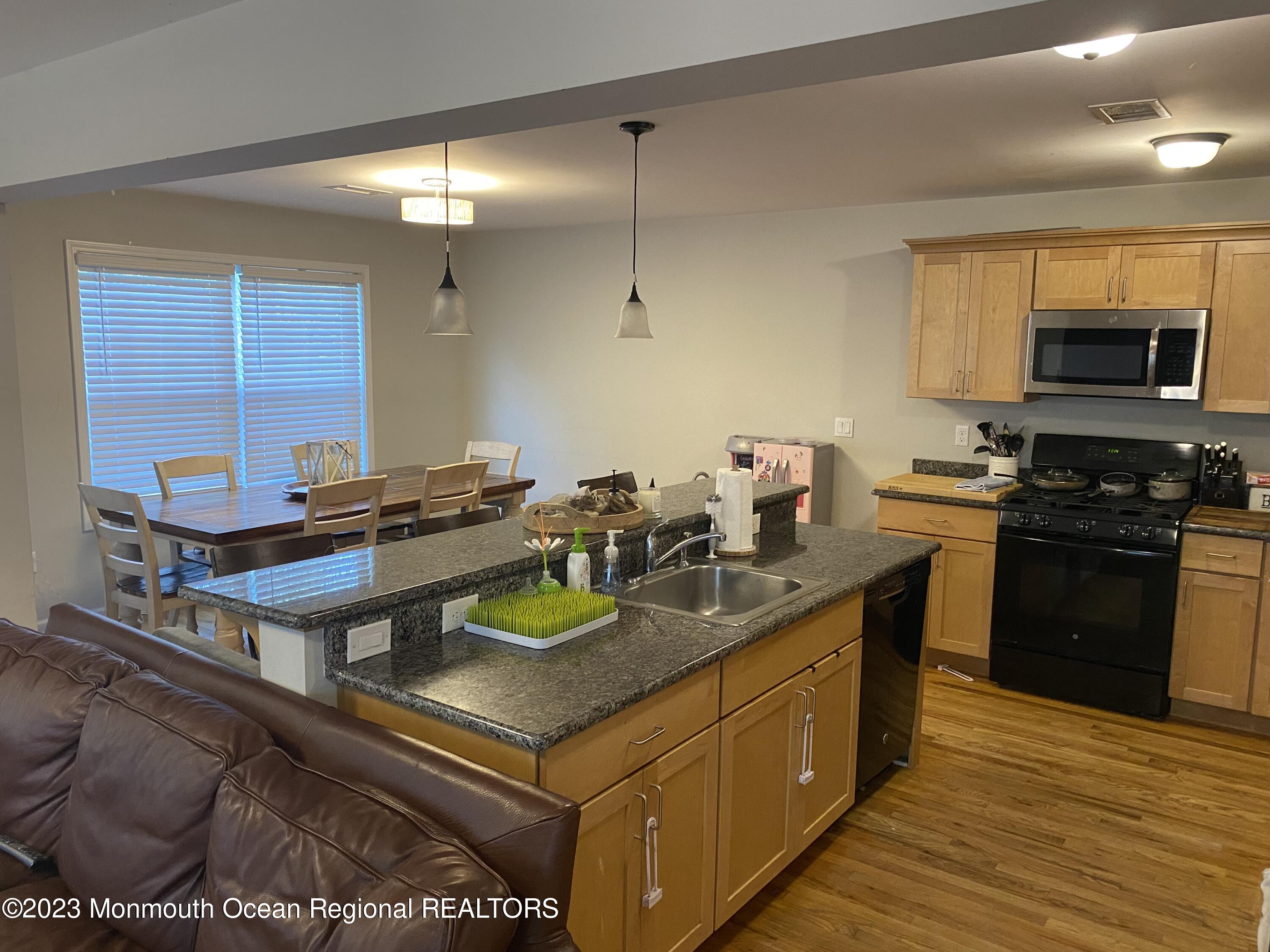 59 Court Street, Unit 2 Long Branch, NJ 07740 - Photo 4 of 8 a kitchen with a sink a stove and cabinets