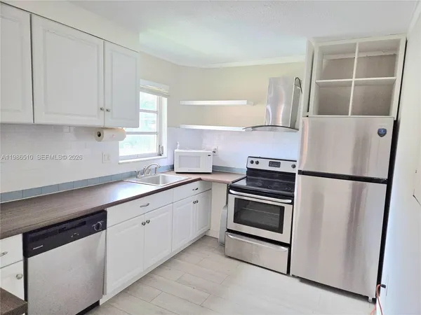 a kitchen with cabinets and stainless steel appliances