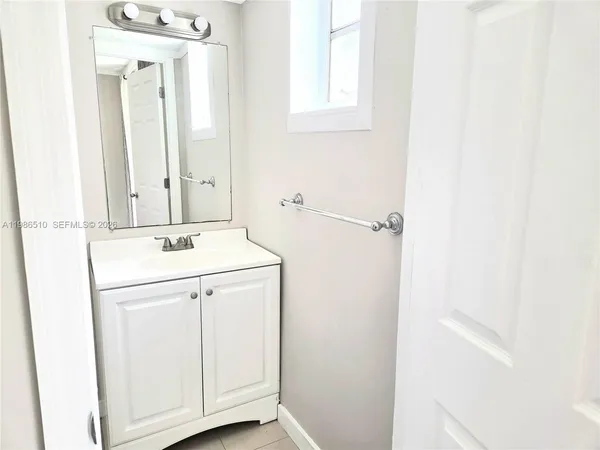a bathroom with a granite countertop sink toilet and mirror