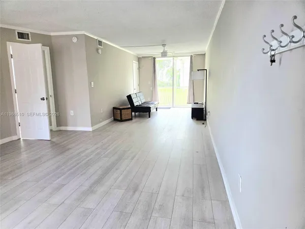 a view of a room with wooden floor and furniture
