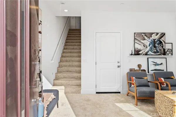 a view of hall way with furniture and stairs