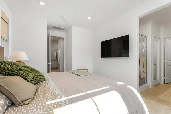 a bedroom with a bed and a flat screen tv