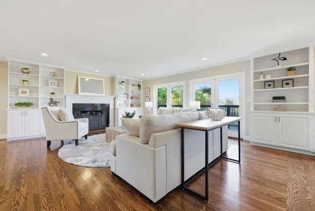 a living room with fireplace furniture and a wooden floor