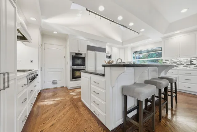 a kitchen with white cabinets and counter space