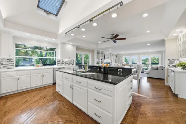 a kitchen with stainless steel appliances kitchen island granite countertop a sink and cabinets
